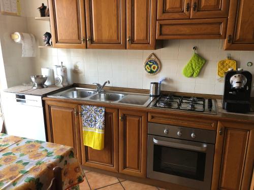 kuchnia ze zlewem i kuchenką w obiekcie Casa Tiziana w mieście Lavena Ponte Tresa