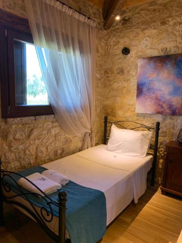a bedroom with a bed and a window at Villa Danae in Meganisi