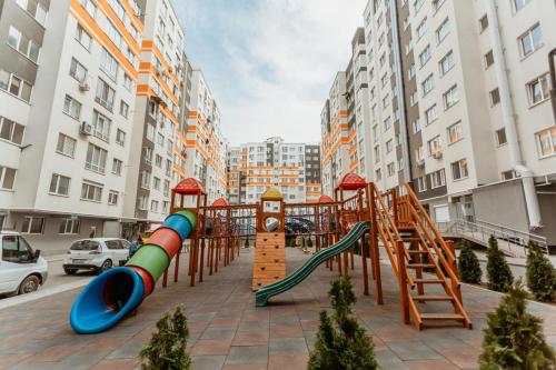 a playground with a slide and a clock in a city at Telecentru, panoramic apartment in Chişinău
