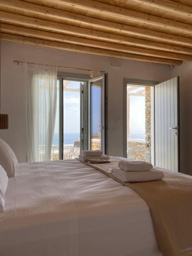 アポロニアにあるGerofinikas Boutique Hotelの海の景色を望むベッドルーム1室(大型ベッド1台付)