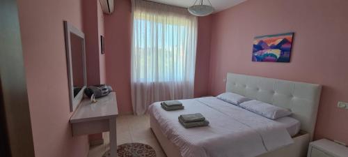 een slaapkamer met een groot bed in een roze muur bij FRESKIA GOLEM in Golem