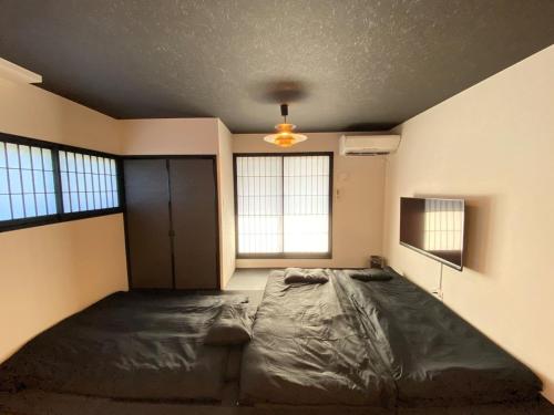 1 dormitorio con 1 cama grande en una habitación con ventanas en Ninja Hotel Kamakura - Vacation STAY 58171v, en Kamakura