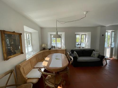 a living room with a table and a couch at Chiemgau, Seeblick, Haus am Weinberg, 83370 Seeon Oberbayern in Seeon-Seebruck