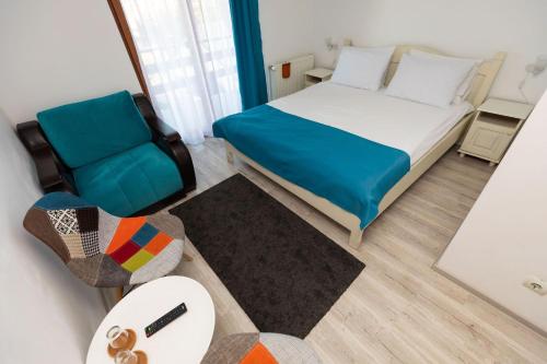 a small bedroom with a bed and a chair at Pensiunea Craiul Muntilor-Ranca in Ranca