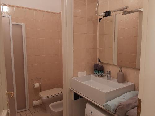 y baño con lavabo, aseo y espejo. en Casa Alberoni, en Rávena