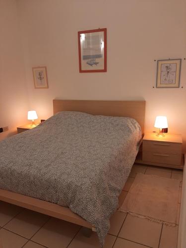 a bedroom with a bed and two night stands with lamps at Casa Alberoni in Ravenna