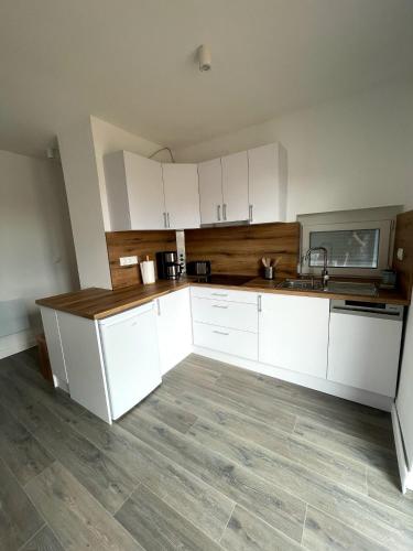 an empty kitchen with white cabinets and a sink at Villa Field6 in Révfülöp