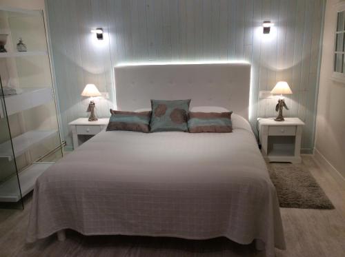 a bedroom with a large white bed with two lamps at Suite EUGENIE piscine MAISON BLANCHE TULLE in Tulle