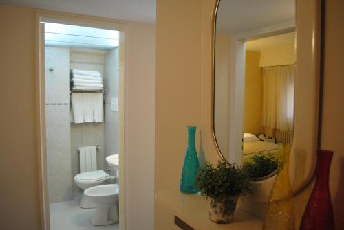 a bathroom with a sink and a toilet and a mirror at San Marco Hotel in La Plata