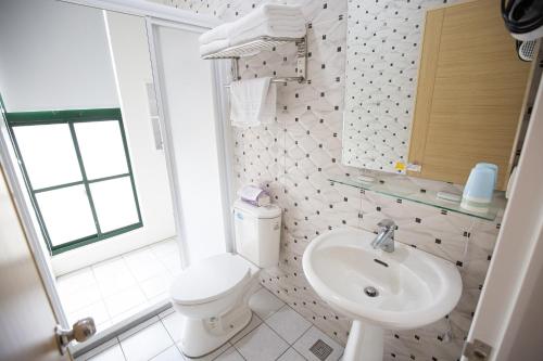 a white bathroom with a toilet and a sink at Jia-Jia Business Hotel in Luodong