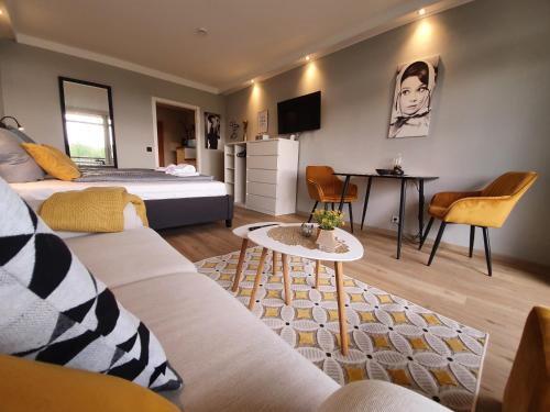 ハーネンクレー・ボックスヴィーゼにあるHarz Enjoy - Vier Jahreszeitenのベッドルーム1室(ベッド1台付)、リビングルームが備わります。