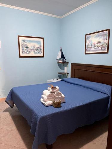 una camera da letto con un letto blu con asciugamani sopra di La Villa Del Patrizio a Ostia Antica
