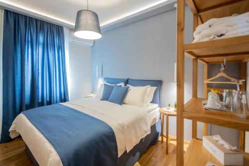 Schlafzimmer mit einem Bett mit blauen Vorhängen in der Unterkunft GIARDINO High living suites in Drama
