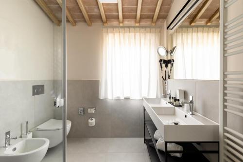 a bathroom with two sinks and a toilet at Agriturismo Pensieri di Cavatina in Castelnuovo Berardenga