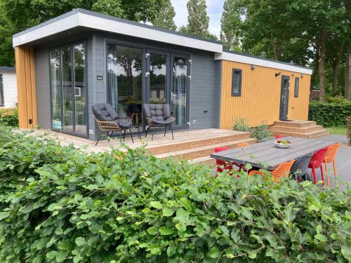 a tiny house with a table and chairs on a deck at Chalet Mariënberg in Mariënberg
