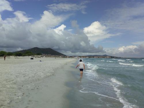 a woman walking on the beach at Casa a pochi passi dal mare in La Caletta