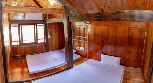 a room with two beds in a wooden cabin at Ba Be Green Homestay in Bak Kan