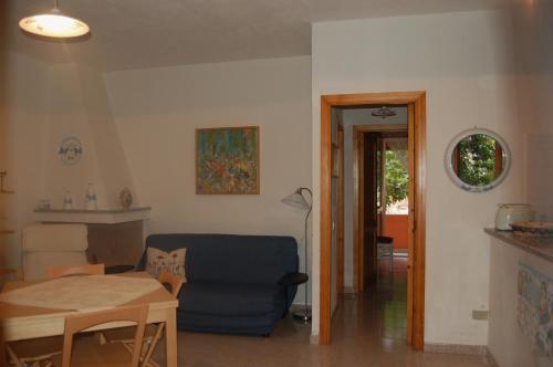 a living room with a blue couch and a table at Casa a pochi passi dal mare in La Caletta