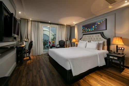 Un dormitorio con una gran cama blanca y una ventana en Scent Premium Hotel en Hanói