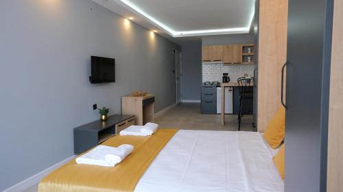 a bedroom with a large bed and a kitchen at LİKYA202 APARt OTEL in Demre