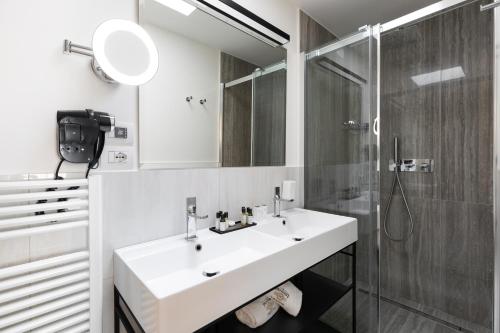 a white bathroom with a sink and a shower at Pensieri di Cavatina in Castelnuovo Berardenga