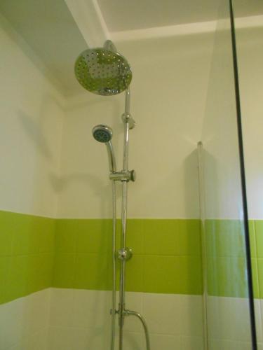 La salle de bains est pourvue d'une douche à rayures vertes et jaunes. dans l'établissement Appartement 3 pièces au coeur d'Hendaye plage, à Hendaye