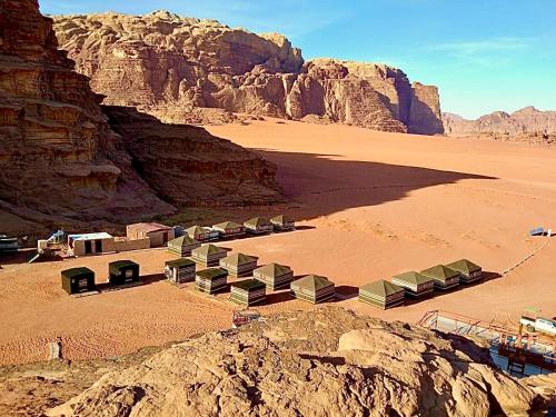 a group of tents in the desert near a mountain at Wadi Rum POLARIS camp in Wadi Rum