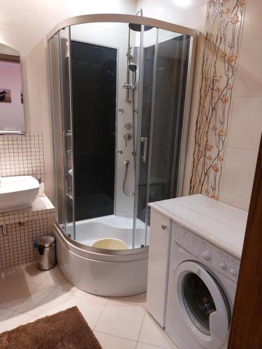 a bathroom with a shower and a washing machine at 9 APARTAMENT VILLA NORD - parking in Jastrzębia Góra