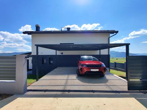a car garage with a red car parked in it at Villa Biser Gacke in Sinac