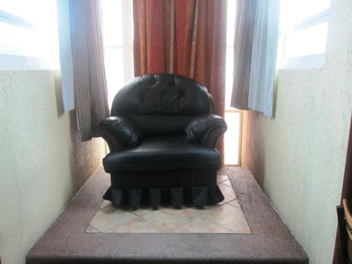 a black chair sitting in the corner of a room at Hotel Real Azteca in Mexico City