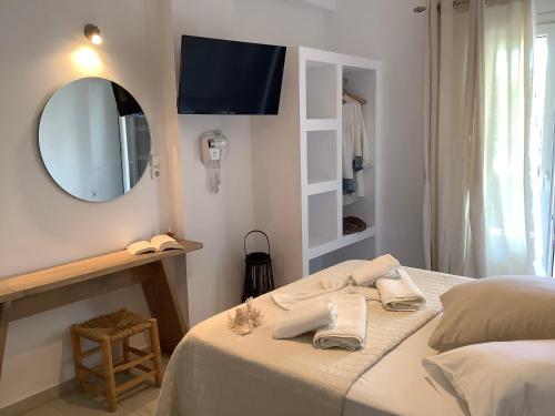 a bedroom with a bed with a mirror and a sink at Asteras in Antiparos Town