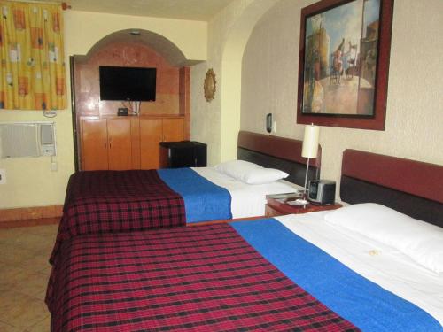 a hotel room with two beds and a tv at Hotel Real Azteca in Mexico City