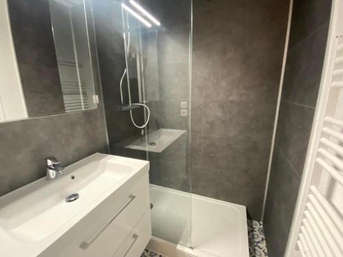 W łazience znajduje się biała umywalka i prysznic. w obiekcie Appartement COSY avec piscine, accès direct plage w mieście Lacanau-Océan