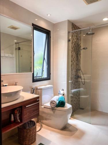 a bathroom with a toilet and a sink and a shower at The Title Rawai: Beachfront condotel in Rawai Beach