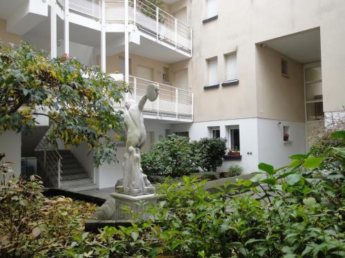 une statue d'une femme et d'un enfant devant un bâtiment dans l'établissement Apollon home Robertsau, à Strasbourg