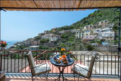 einen Tisch und Stühle auf einem Balkon mit Aussicht in der Unterkunft Casa Mamà in Positano
