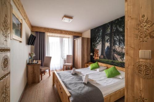 a hotel room with a bed with green pillows at Hotel Eco Tatry Holiday& Spa in Kościelisko