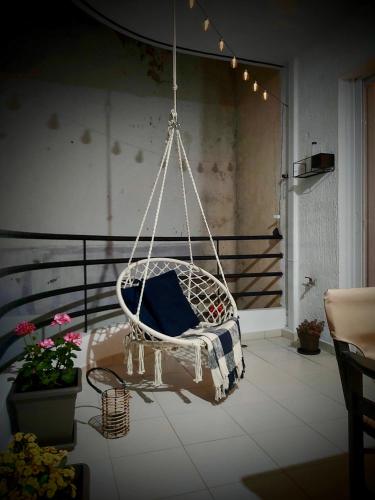 a white swinging chair with a blue pillow on a balcony at Casa Di Penny 2 in Kyparissia