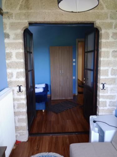 a hallway with blue walls and a wooden door at Soul boutique hotel in Monodendri