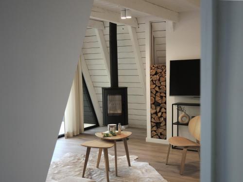 a living room with a table and a fireplace at Domki MODERN Jezioro Nyskie in Nysa
