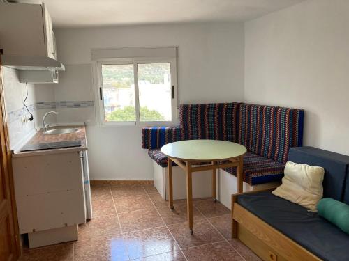 una pequeña cocina con mesa y sofá en La casa de Paco el Ventero El Secadero, en Almócita