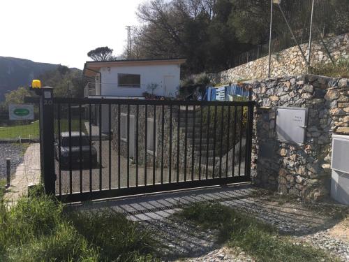 a black gate with a stone wall and a house at Belvedere20guesthouse in Finale Ligure