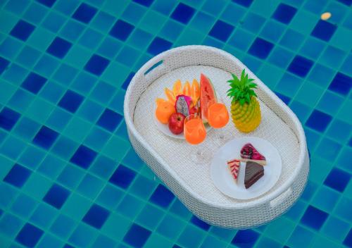 a plate of fruit in a swimming pool at Room@Gallery Pool Villa in Pattaya South