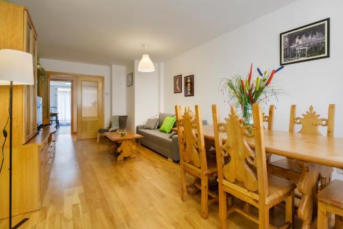 a dining room and living room with a table and a couch at Apartamentos IRENE en el Pirineo Aragonés in Sabiñánigo