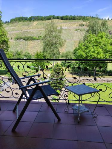 a chair and a table on a balcony with a view at Gästehaus Schneider in Brauneberg