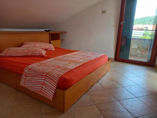 アシェーアにあるCasa Vacanze un sogno al mareのベッドルーム1室(赤い掛け布団、窓付)