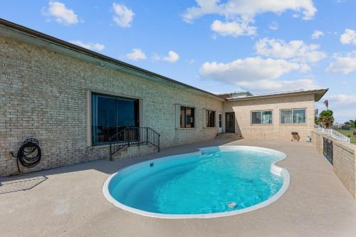 a swimming pool in the backyard of a house at Bay Dreamer - Massive Bayfront Home with Private Pool home in Galveston