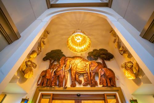 a group of elephants on the wall of a building at Siri Nakornpink Chiang Mai Hotel SHA Plus in Chiang Mai