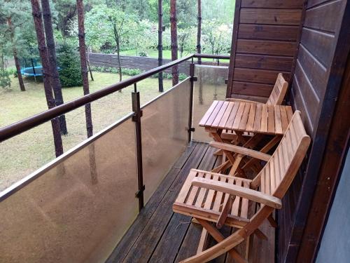 zwei Stühle und ein Tisch auf einer Veranda in der Unterkunft forest-house lt in Druskininkai