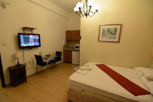 a bedroom with a bed and a tv in a room at City Center Apartments in Haifa